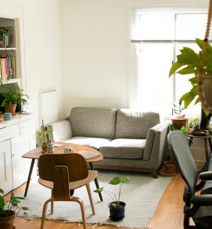 Gray fabric loveseat near brown wooden table