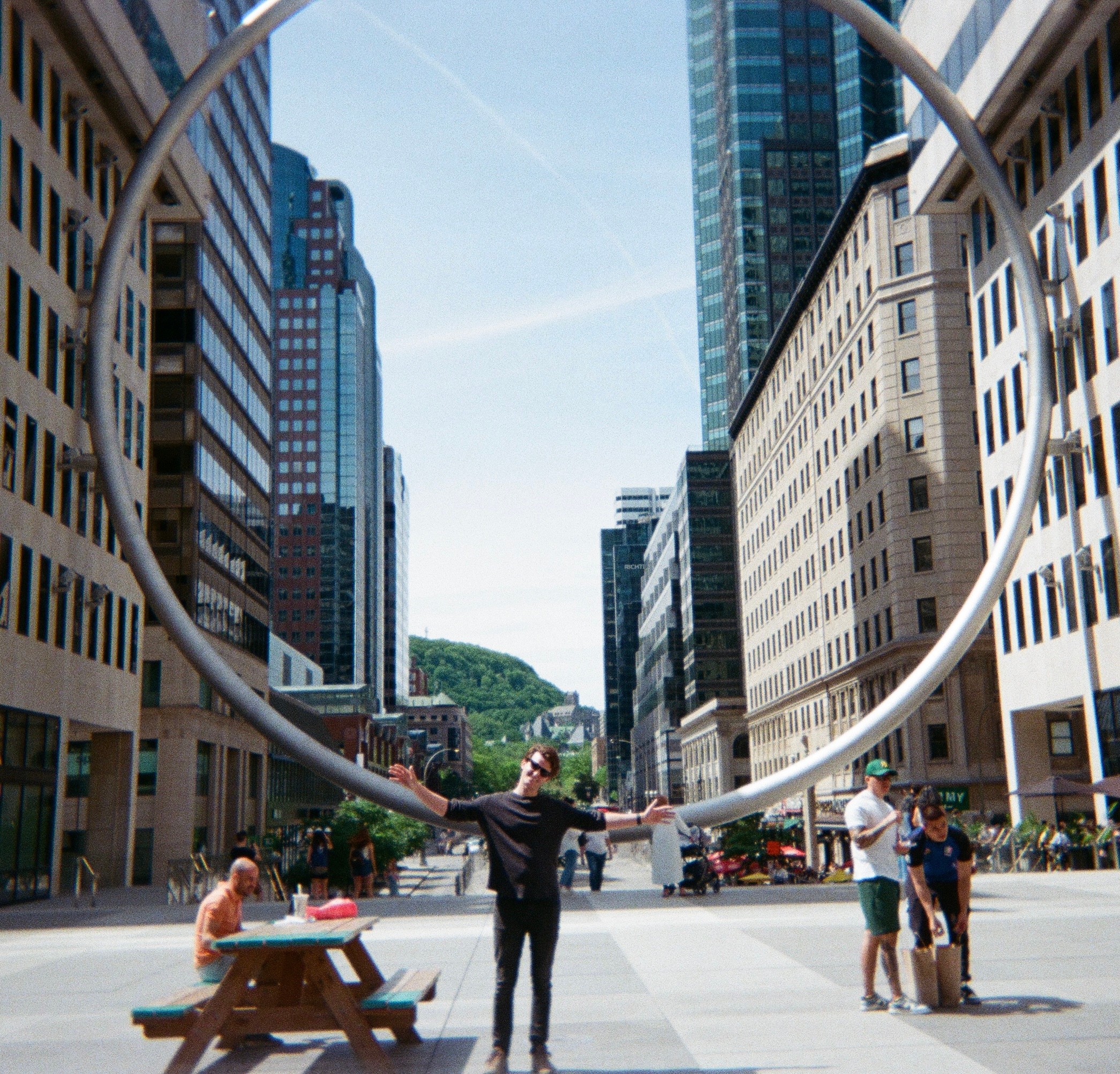 A tourist man standing in front of a large ring structure landmark in the city